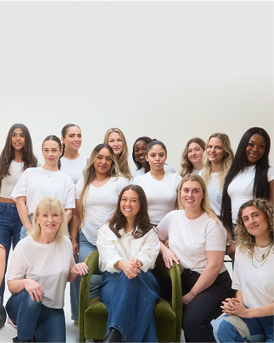 Group of women smiling and posing together in casual attire.